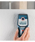 Heavy Duty Digital Stud Finder Wall Scanner with precise detection controls in hand, scanning a wall for hidden objects.