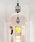10.63 Inch Black Farmhouse Chandelier with Four Lights installed in hallway, showcasing rustic metal cage design and adjustable E12 base.