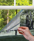 Hand applying Heat Control Platinum Window Film For DIY Install Energy Saving Sun Blocking Tint That Slashes Heat Blocks 99 Percent UV