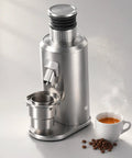 Hella Dope Electric Espresso Grinder With 80mm Stainless Steel Flat Burrs and Super Smooth Stepless Dial next to a steaming cup of coffee.