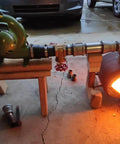 Electric Blacksmith Forge Blower 110V 250W for coal fires shown in use, connected to forge with flame, on wooden support