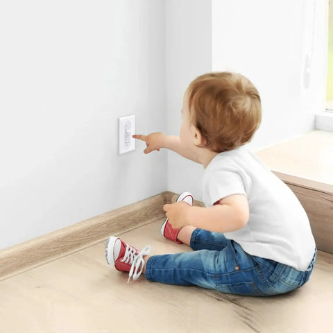 Baby reaching for Toggle Style Wall Switch Guard For Kidproof Home Safety Clear Light Switch Cover installed on wall