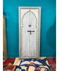 Hand Carved White Barn Door For Interior Use Rustic Solid Wood Door In Custom Sizes For Sliding Or Hinged Mounts Double Or Single Door Antique Style Architectural Woodwork Made To Order Standard 71x34 Inch Size, front view against blue wall