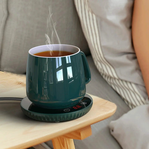 Tempered Glass Top Cup Warmer Pad With Digital Display And Auto Timer To Keep Your Morning Brew Piping Hot And Dodge The Cold Coffee Blues On Busy Weekdays with steaming cup on side table.