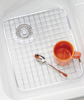Stainless Steel Sink Grid Protector Kitchen And Bath Rugged Dish Rack in sink with orange mug and spoon, 12.75x11 inches.