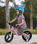 Electric Balance Bike For Kids With 14 Inch Tires Pink Ages 3 To 7 Kid Friendly Three Speed Modes Up To Nine MPH Lightweight 16.5 Lbs Frame Nine Mile Range Light Up Front Tire Adjustable Seat Safe Magnesium Alloy Build, child riding outdoors