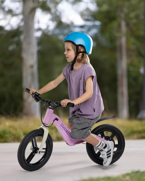 Electric Balance Bike For Kids With 14 Inch Tires Pink Ages 3 To 7 Kid Friendly Three Speed Modes Up To Nine MPH Lightweight 16.5 Lbs Frame Nine Mile Range Light Up Front Tire Adjustable Seat Safe Magnesium Alloy Build, child riding outdoors