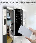 Hand holding 10 Pack Writable 125kHz T5577 RFID Cards Blank White Proximity Badges for Easy Access Control near door reader.