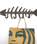 Handcrafted Cast Iron Fish Bone Wall Hooks Vintage Coastal Coat Rack And Entryway Key Holder With Mounting Screws, 13x4 inches, holding a bag.