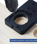 Front view of 35mm hinge boring jig kit, black plastic drilling guide clamped to wood with drill bit