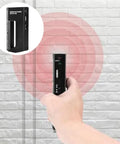Metal Detector - Wire Finder Wall Scanner, Stud Sensor Hardware Tool being held in hand, detecting wires on a white brick wall.