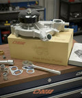 Water Pump With Thermostat Go To Replacement For Chevy GMC V8 Engines on workbench with packaging and tools