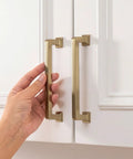 Hand installing Champagne Bronze Cabinet Pulls 10 Pack 5 1 16 Inch Solid Zinc Alloy Modern Square Drawer Handles on white kitchen cabinet.
