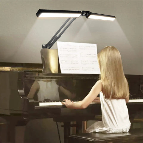 Two In One LED Desk Lamp With Dual Heads And Clamp Or Base Mount, 24W eye care workbench light, illuminating a piano music sheet.