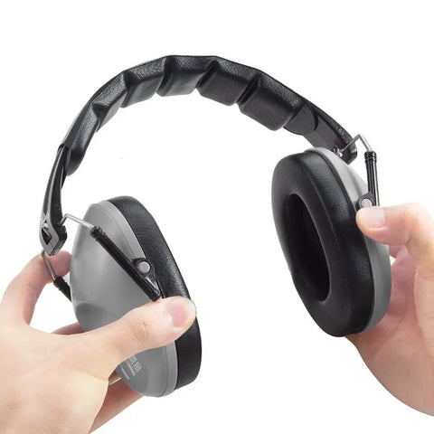 34 dB NRR Hearing Protection Ear Muffs For Loud Events And Sensory Use Ultra Slim And Lightweight Design For All Day Comfort Yet Durable High Noise Reduction Earmuffs For Concerts And Everyday Noise Grey. Hands adjusting the padded adjustable headband of slim grey earmuffs.
