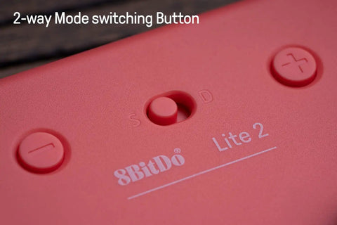 Pocket Sized Lite 2 Bluetooth Controller With Motion Controls, close-up of 2-way mode switching button, pink wireless gamepad.