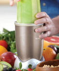 Person using 900W Nutribullet blender surrounded by fruits, showing Milling Blade Replacement For Nutribullet 600W And 900W Blenders.