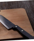 Knife with black handle on a wooden board showcasing Locking Knife Handle Rivets Kit Pro Grade Two Piece Durable Stainless Steel Fasteners