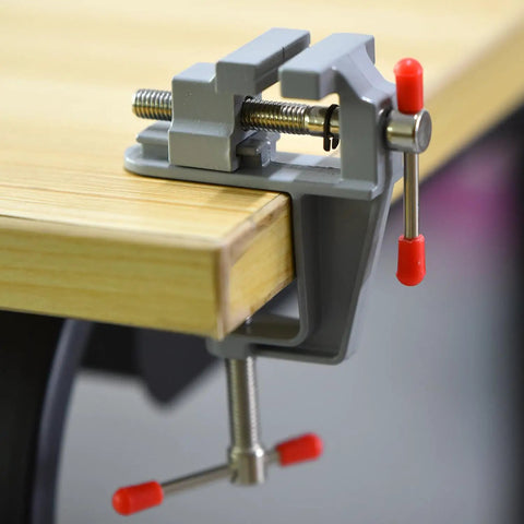 Mini Jeweler Table Clamp For Jewelry Making And Electronics Craft Projects Portable Bench Vise Great For Small Repairs And Model Building Handy Tiny Work Clamp For Crafting Jewelry DIY Projects And Hobbyists, installed on a table.
