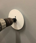 Drill using Drywall Repair Kit With Tapered Hole Saw And Two Plugs For Clean Flat Patches on a wall