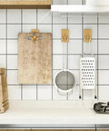 Modern Wall Mounted Coat Rack With Smooth Beige Finish Sleek Space Saving Design For Entryways holding kitchen tools on a tiled wall.
