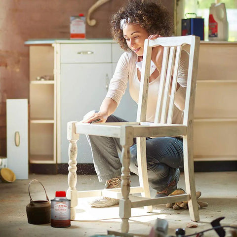 Person applying Fast Drying Boiled Linseed Oil For Wood Care to wooden chair in workshop setting