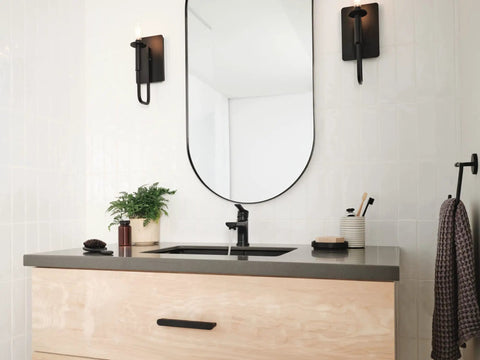 Flute Matte Black Bathroom Faucet With 0.5 GPM Flow Fits 1 Or 3 Hole 4 Inch Install centered on a modern bathroom sink