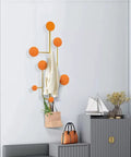 Hella Sturdy Wall Mount Coat Rack With Creative Cloak Hooks For Entryway Organization, displaying orange hooks and a light sweater.