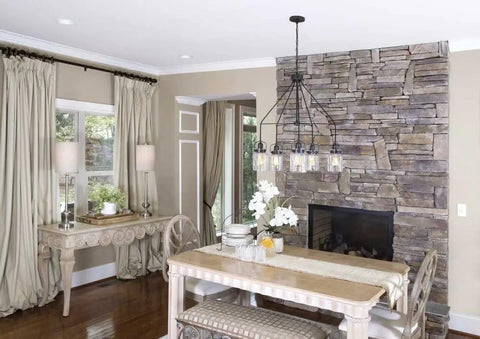 Dining area with stone fireplace, modern ceiling light, Topsail Three Light Inverted Pendant in polished chrome, sleek design
