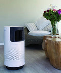 Portable Evaporative Air Cooler For Bedroom And Office Electric Standing Cooling Fan in white beside a wooden table and flowers.