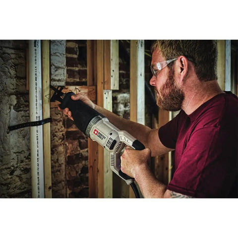 Man using Heavy Duty 7.5 Amp Variable Speed Corded Reciprocating Saw for cutting wood and metal at job site.