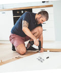 4-pack silver screw-on metal hinges for interior doors; man kneels on the floor with a drill to install hardware.