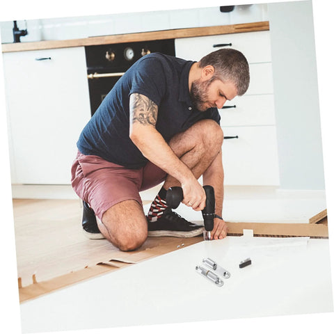 4-pack silver screw-on metal hinges for interior doors; man kneels on the floor with a drill to install hardware.