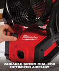 Person adjusting variable speed dial on 18V Brushless Packout Fan With Lightning Fast Cooling, Beastly 850 CFM, rugged red build