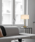 Kendal Metal Table Lamp with Pull Chain Switch on side table in living room, featuring drum fabric shade and weighted base