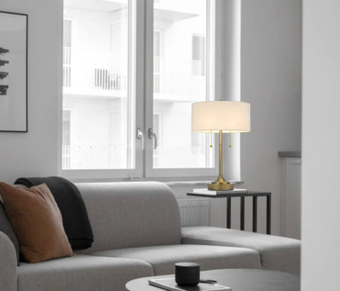 Kendal Metal Table Lamp with Pull Chain Switch on side table in living room, featuring drum fabric shade and weighted base