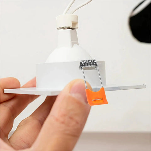 Lawsen Spring Clips Recessed Lighting 200pcs spring clips holding downlight fixture with spring tension and clip in hand.