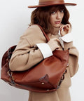 Woman carrying leather purse with DIY Bag Corner Repair Kit For Purses And Leather Bags With Corner Patches Cone Needle Thread