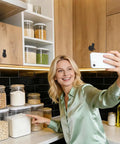 Woman taking selfie in kitchen with Vintage Cat Drawer Knobs Set Of 4 Black Iron Cabinet Handles visible on wooden cabinets