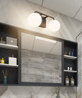 Two Light Mid Century Vanity Lights Over Mirror Matte Black With Milk White Glass Globes in bathroom setting