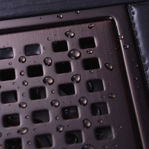 Close-up of 6 Inch Square Shower Floor Drain Brushed Bronze 304 Stainless Steel with visible water droplets.