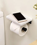 Modern Matte Black Toilet Paper Holder With Shelf, Wall Mounted Bathroom Tissue Dispenser featuring phone on marble shelf.