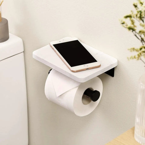 Modern Matte Black Toilet Paper Holder With Shelf, Wall Mounted Bathroom Tissue Dispenser featuring phone on marble shelf.