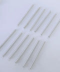 Twelve Pc Heavy Duty Mechanical Compression Springs With Hook Ends For DIY Mods And Home Repairs Made From Fatigue Resistant Spring Steel on a light surface.