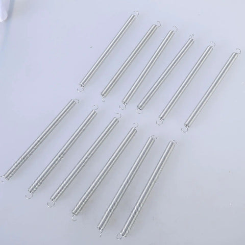 Twelve Pc Heavy Duty Mechanical Compression Springs With Hook Ends For DIY Mods And Home Repairs Made From Fatigue Resistant Spring Steel on a light surface.