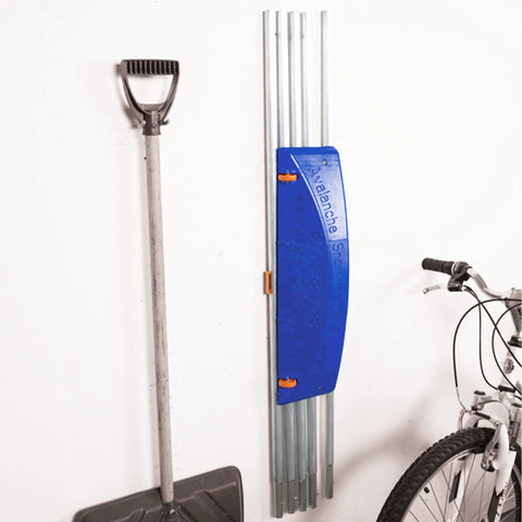Heavy Duty Extendable Roof Snow Rake With Gliding Rubber Wheels And Lightweight Aluminum Handle, stored with a shovel.
