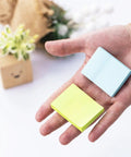 Hand holding Small 1.5x2 Inch Sticky Notes, 50 Pads With 50 Sheets Each, 10 Bright Colors Recyclable Self Stick Pads for notes