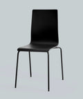 Black molded plastic dining chair with curved back and slim metal legs.