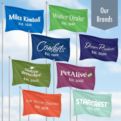 Seven branded flags flying under a clear sky, labeled 'Miles Kimball', 'Walter Drake', 'Easy Comforts', 'Dream Products', 'Native Remedies', 'PetAlive', 'Fox Valley Traders', and 'StarCrest'.