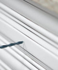 Close-up of DIY Friendly No-Fuss All In One Cabinet Door And Drawer Drill Mounting Template with drill bit on white cabinet door